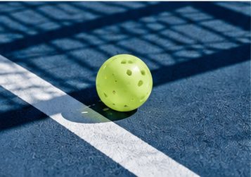 Pickleball on a blue court line